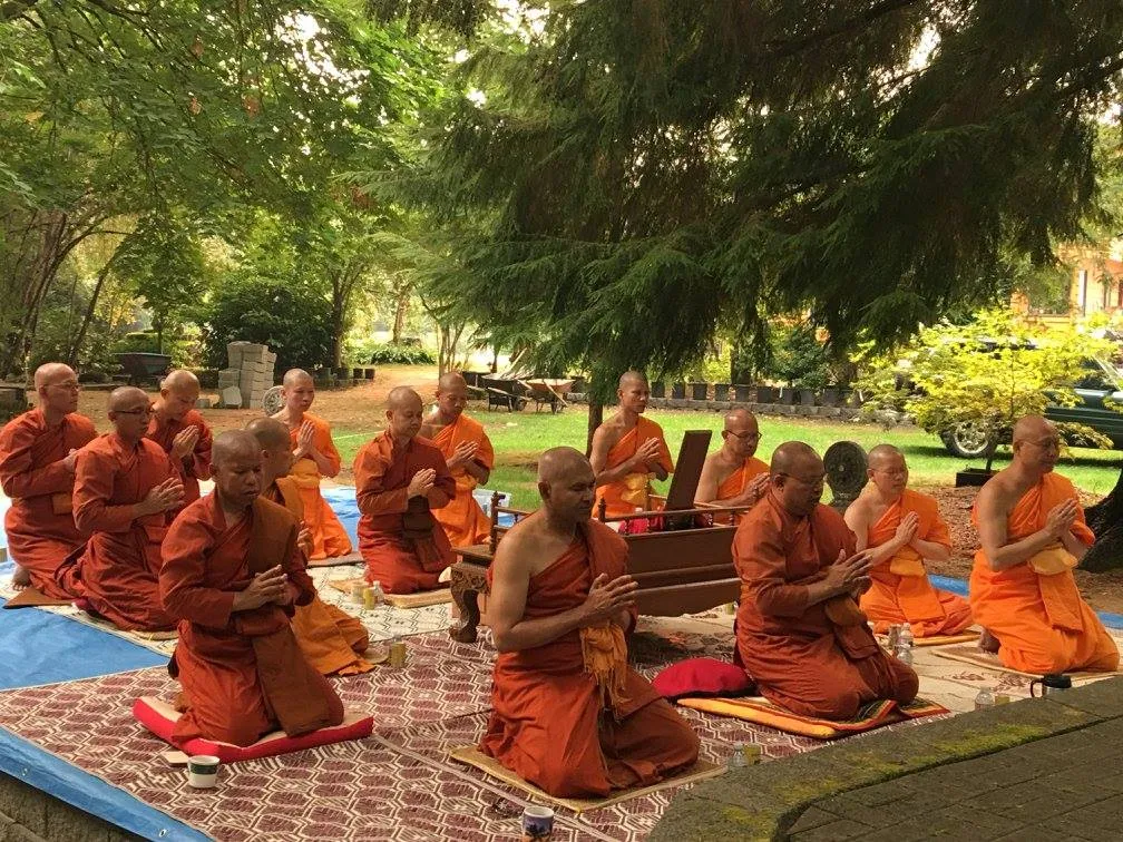 Several monks chanting in the courtyard