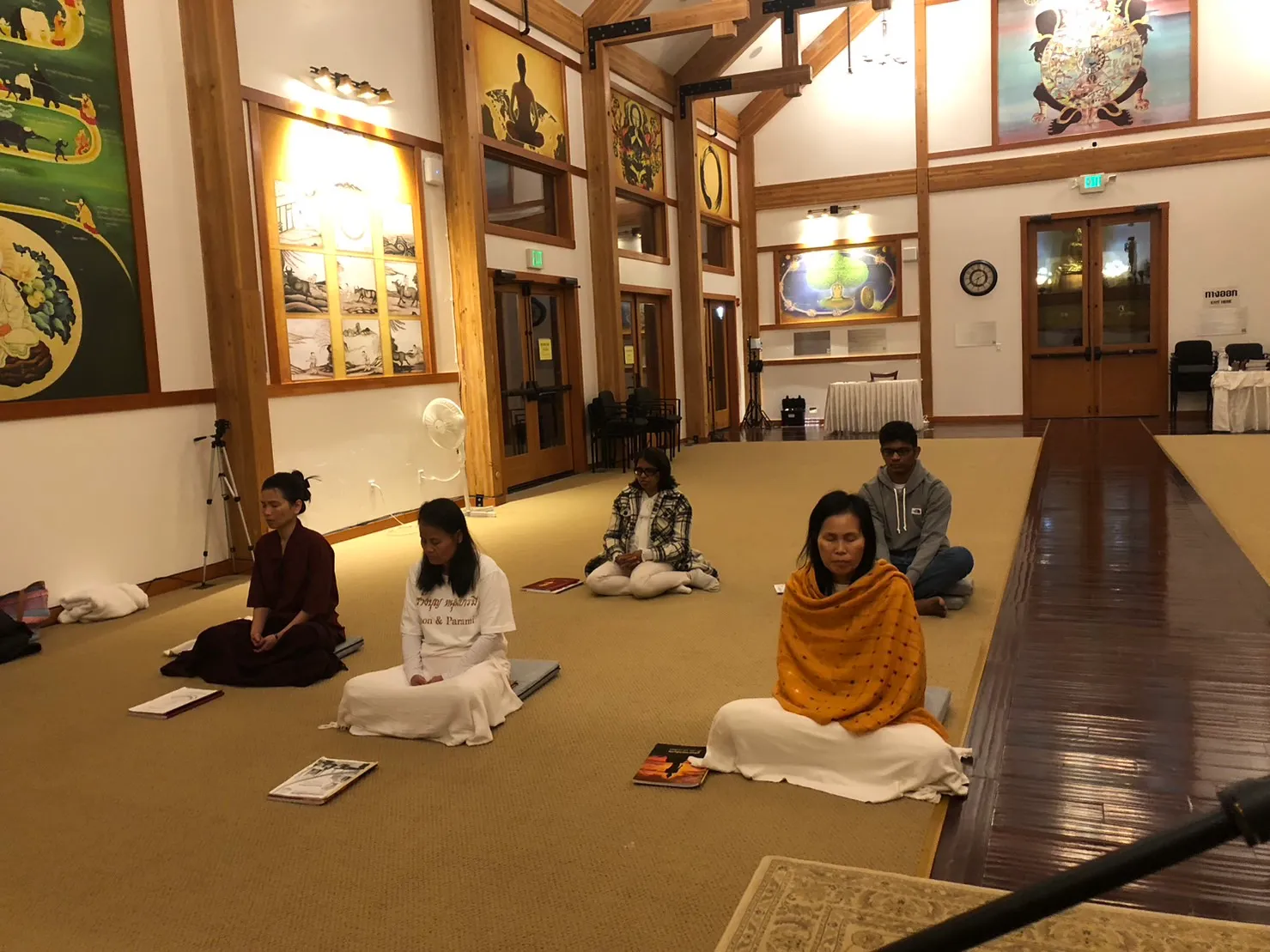 Several people meditating in a meditation room in a Wednesday evening